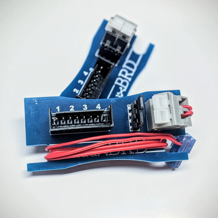 A pair of QuickSplit-4 breakout boards. One has a red wire wrap up for storage.