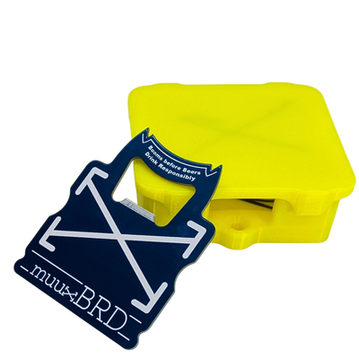 muuxBRD Bottle Opener leaning up against a slat enclosure